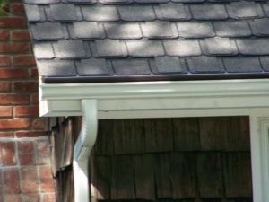 Close up of musket brown gutter cover on dark brown composition roof in Lees Summit, MO