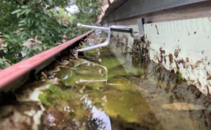 clogged-gutter-ready-to-overflow-because-it-is-so-full-of-water-and-can-not-drain